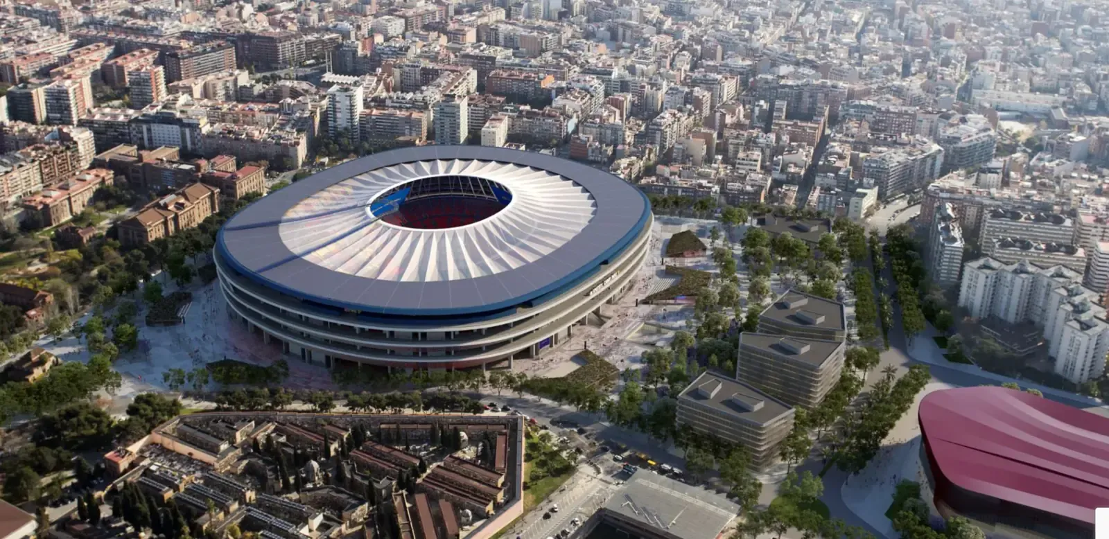Aerial view of a large modern circular football stadium with an open roof design, surrounded by dense city buildings and tree-lined streets in an urban setting.