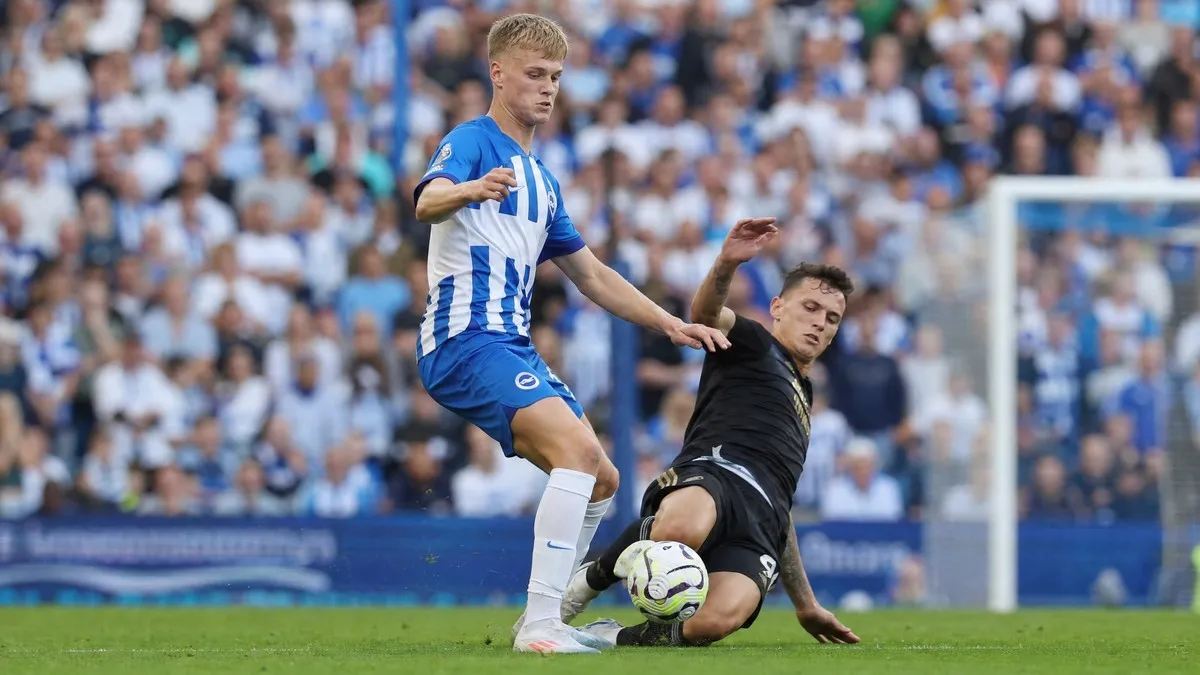Jan Paul van Hecke winning a header in Brighton's blue and white striped kit during a Premier League match at the Amex Stadium