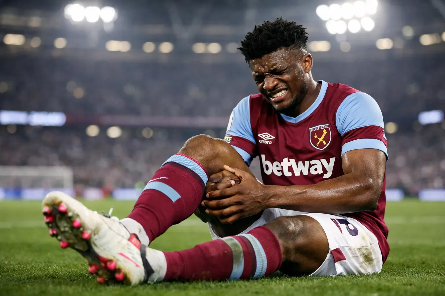A highly detailed and recognizable representation of Mohammed Kudus in a West Ham kit, sitting on the pitch with a pained expression and clutching his leg at the London Stadium.