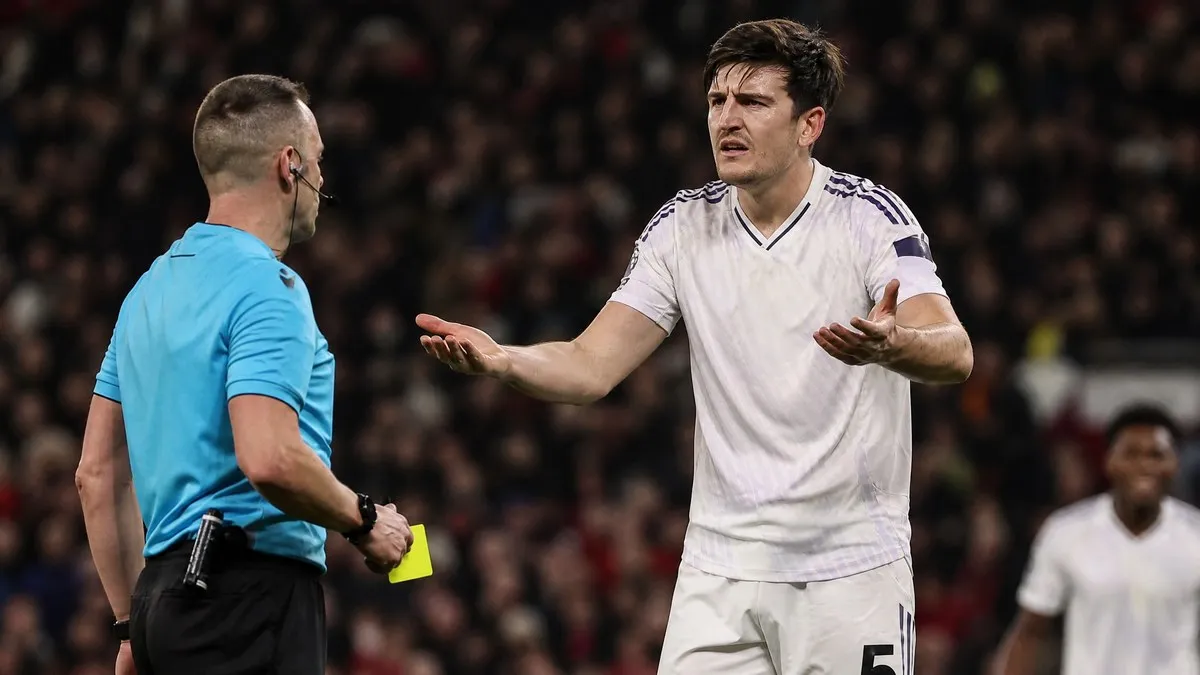 Harry Maguire in Manchester United white kit arguing with a referee after a red card controversy