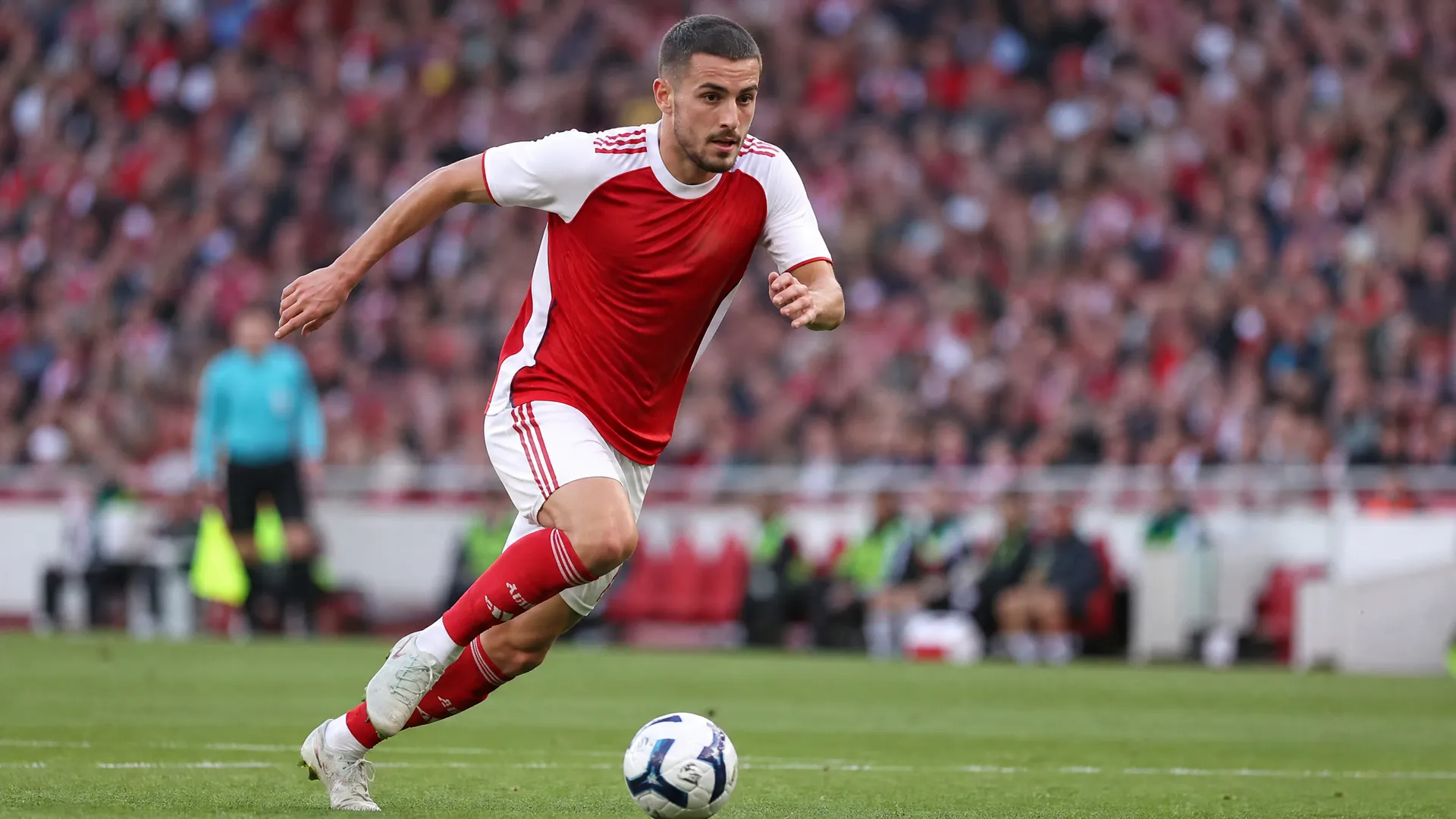 Leandro Trossard driving forward in Arsenal's red and white kit at the Emirates Stadium as Arteta insists he is not for sale