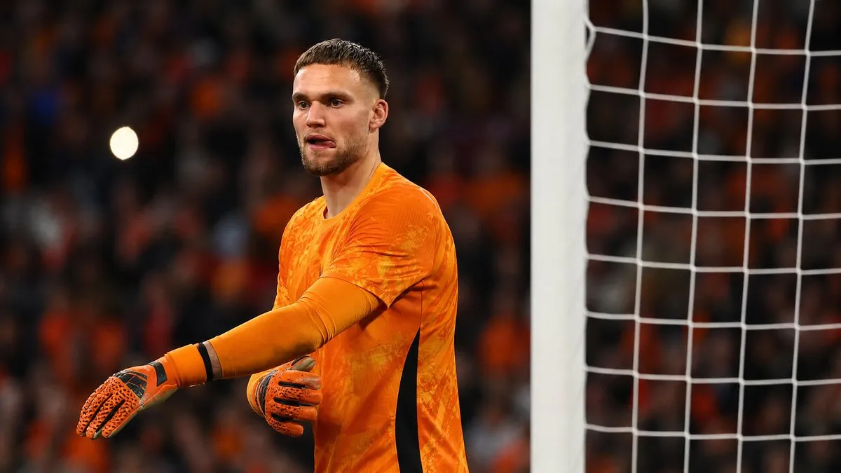 Bart Verbruggen in Netherlands goalkeeper kit standing at his goal ahead of the World Cup match against Japan