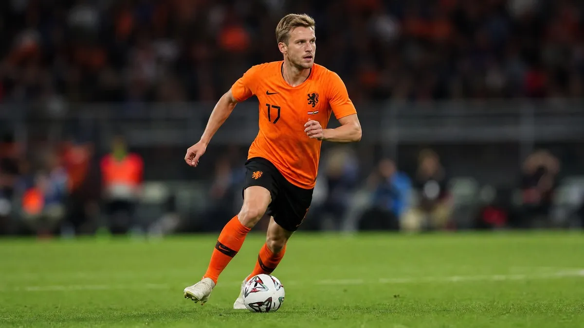 Frenkie de Jong in action, wearing the orange Netherlands kit, dribbling a football on a stadium pitch during a World Cup match.