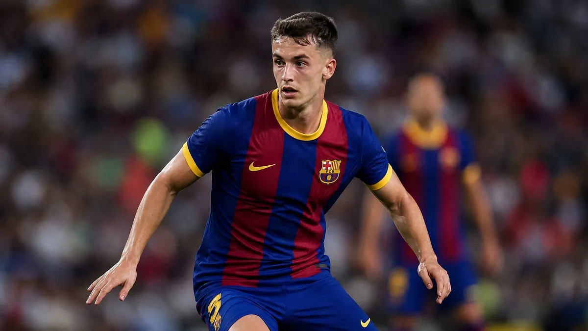Marc Casado in action wearing the FC Barcelona home kit, dribbling the ball on a vibrant football pitch during a La Liga match.