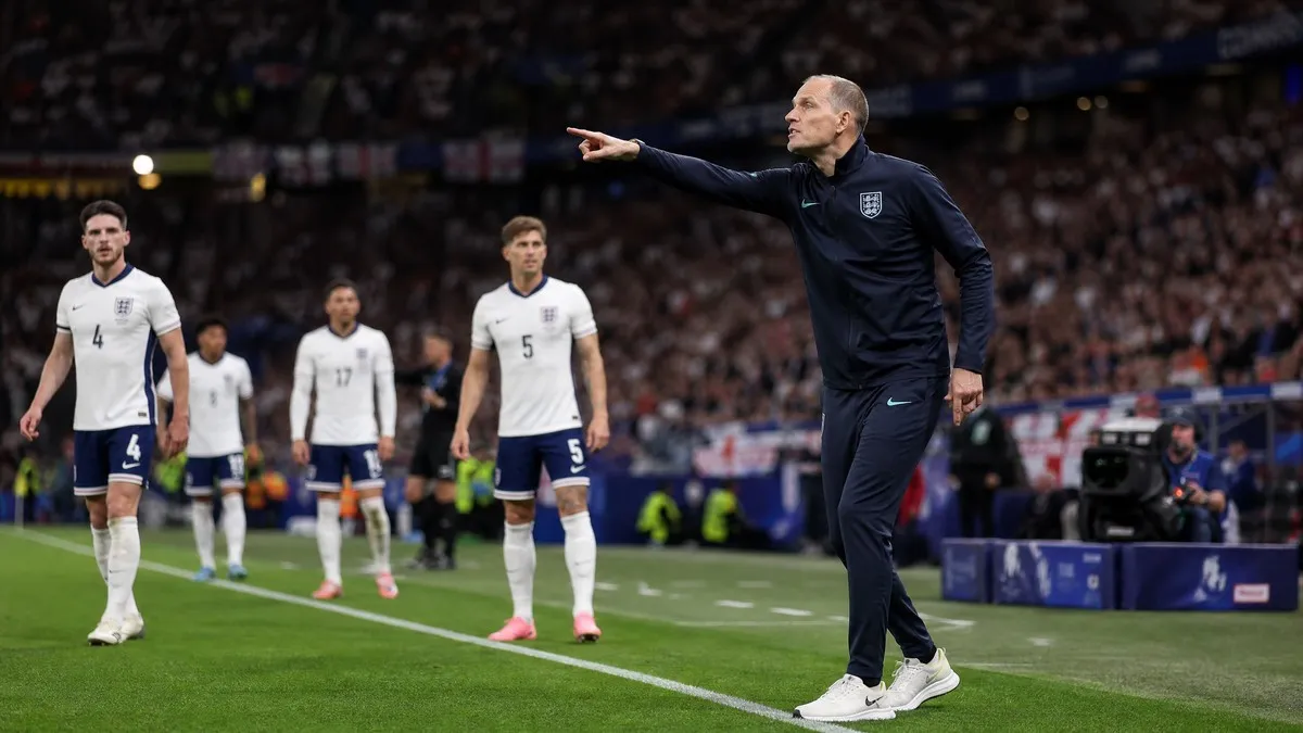 Thomas Tuchel directing England national team on the touchline during a 2026 World Cup match with players in white kit